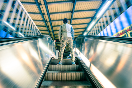 U-Bahn-Treter Mann steht auf Rolltreppe, die nach oben fährt